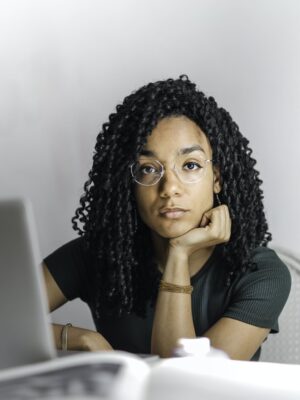 Serious ethnic young woman using laptop at home