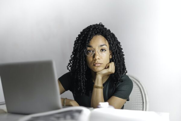 Serious ethnic young woman using laptop at home